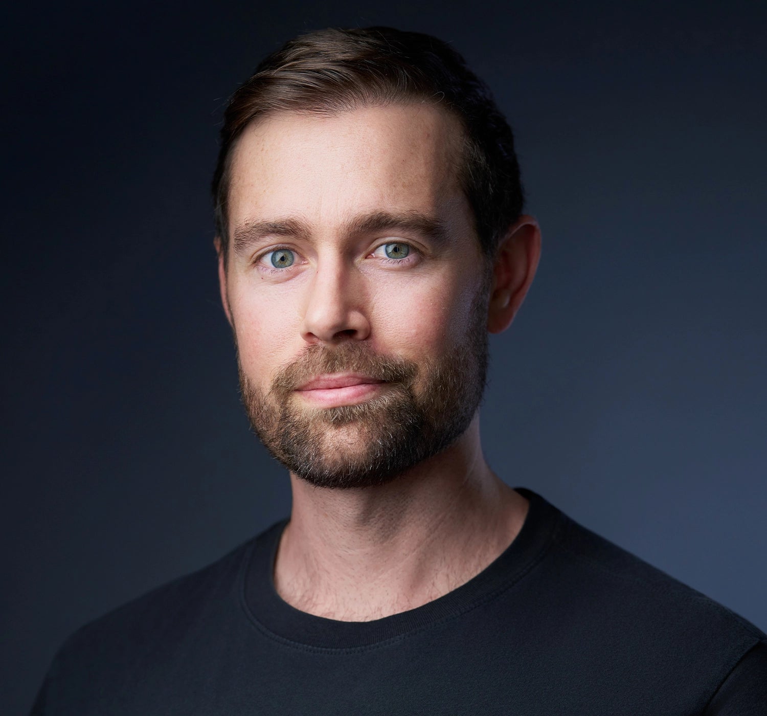 A professional headshot on an navy background