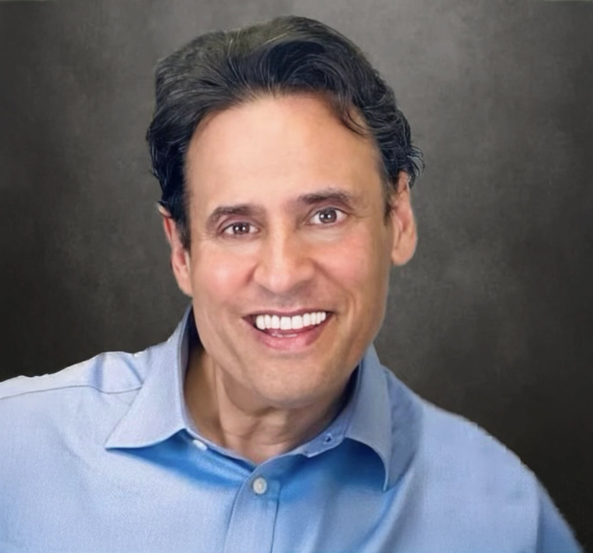 A corporate headshot of Dr. Robert Silverman wearing a blue shirt on a dark background.